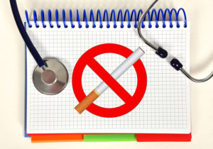 open book with stop alcohol no smoking symbol and stethoscope on desk